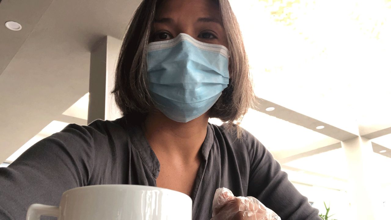 CNN correspondent Atika Shubert sits down for breakfast wearing a face mask and plastic gloves.