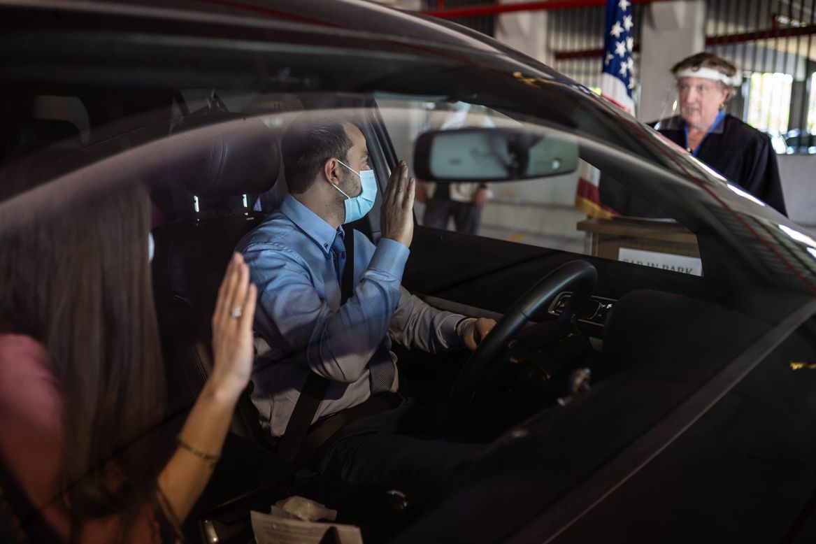 Charbel Abdo Habib and his wife, Rana El-hachem, raise their hands as Federal Magistrate Judge Patricia Morris swears them in during <a href="https://www.usatoday.com/story/news/nation/2020/06/18/immigrants-becoming-citizens-via-drive-thru-ceremonies/3213245001/" target="_blank" target="_blank">a drive-thru naturalization ceremony</a> in Detroit on Wednesday, June 17.