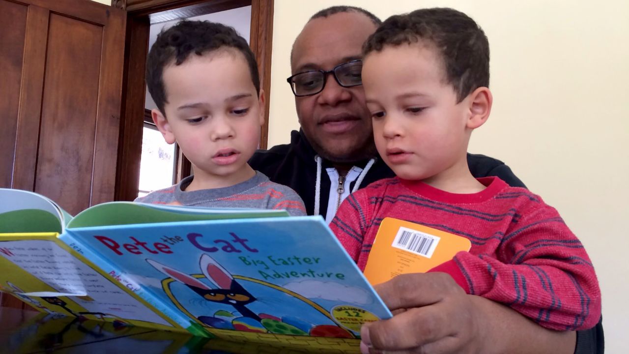 Mabry reads a book to his twin sons.
