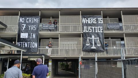 Refugees and asylum seekers hang signs made from bin bags over the balconies at the hotel in Kangaroo Point, Brisbane.