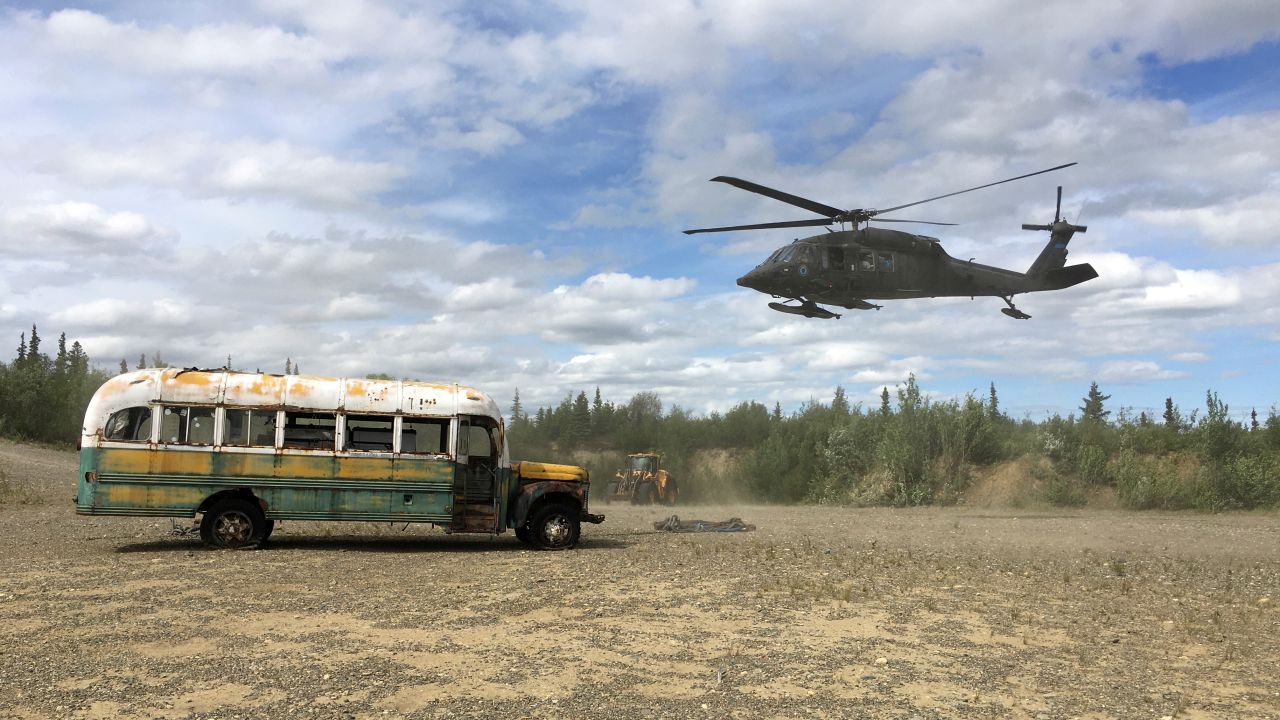 An Alaska Army National Guard UH-60 Black Hawk helicopter hovers near "Bus 142," made famous by the "Into the Wild" book and movie.