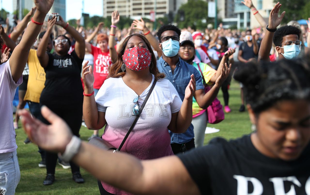 People pray together during a Juneteenth event at Atlanta's Centennial Olympic Park.