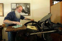  Loren Ackerman prints wooden money on an 1890s-era press in Tenino, Washington
