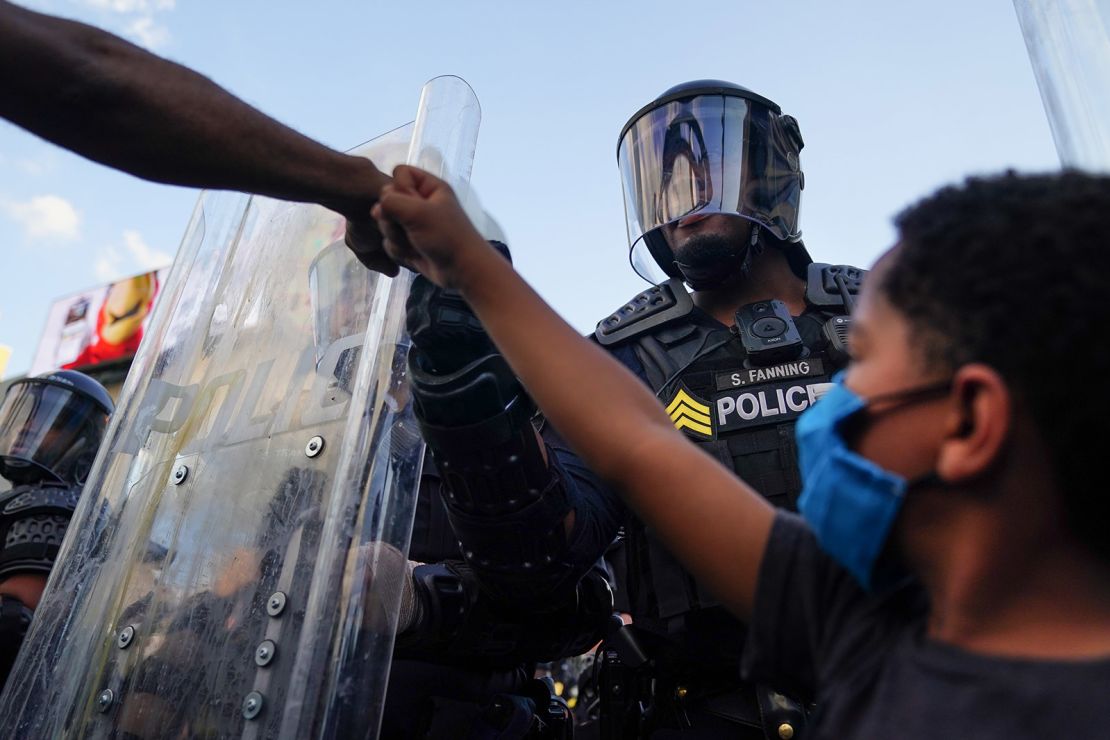 Kai fist-bumps a police officer during the protest in Atlanta on May 31. (Elijah Nouvelage/Getty Images)