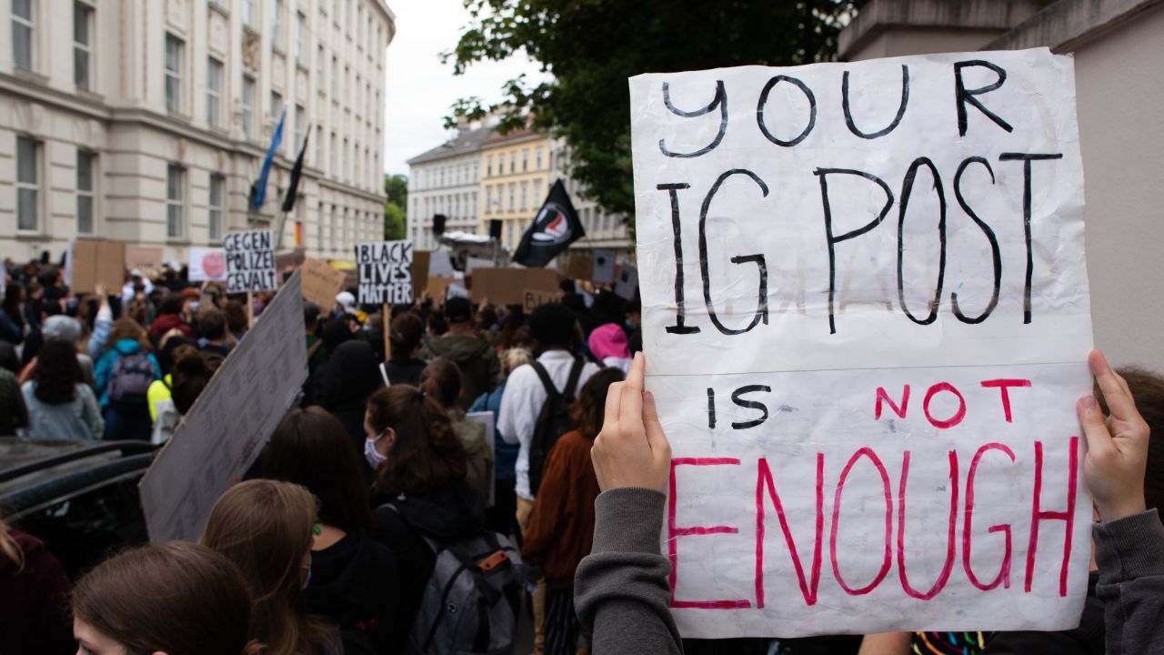VIENNA, AUSTRIA - JUNE 05: A protester holds up a sign reading 'Your IG post is not enough' during a Black Lives Matter protest in front of the U.S Embassy on June 05, 2020 in Vienna, Austria. The death of an African-American man, George Floyd, while in the custody of Minneapolis police has sparked protests across the United States, as well as demonstrations of solidarity in many countries around the world. (Photo by Thomas Kronsteiner/Getty Images)