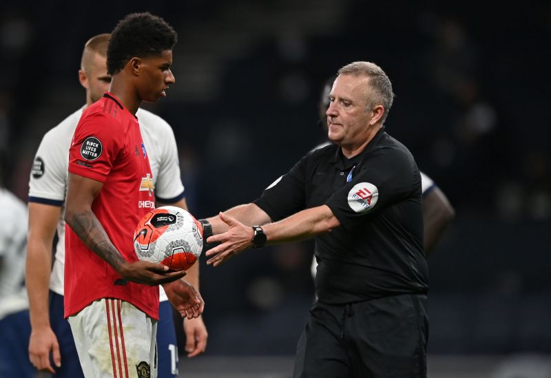 Marcus Rashford takes a knee and raises his fist as