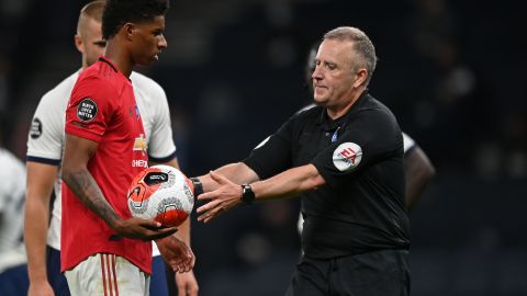 Referee Jonathan Moss takes the ball from Marcus Rashford after wrongly awarding a penalty.