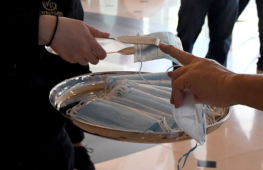 Tongs are used to give surgical masks to guests entering the Westgate Las Vegas Resort & Casino on June 18, 2020 in Las Vegas, Nevada.