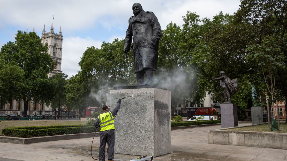 A worker cleans the Churchill statue in Parliament Square that had been spray painted with the words "was a racist" in June 2020 in London.