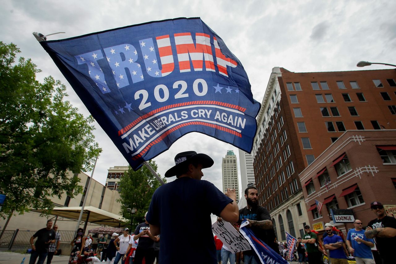 A man waves a Trump flag in Tulsa on Saturday.