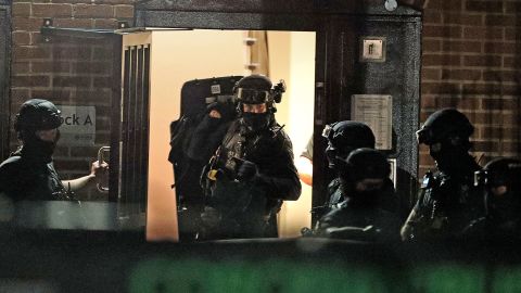 Armed police officers work at a block of flats in Reading after an incident at Forbury Gardens park in the town centre of Reading, England, Saturday.
