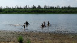 Children play in the Krugloe lake outside Verkhoyansk, the Sakha Republic, about 4660 kilometers (2900 miles) northeast of Moscow, Russia, Sunday, June 21, 2020. A Siberian town that endures the world's widest temperature range has recorded a new high amid a hear wave that is contributing to severe forest fires. Russia's meteorological service said the thermometer hit 38 Celsius (100.4 F) on Saturday in Verkhoyansk, in the Sakha Republic about 4660 kilometers (2900 miles) northeast of Moscow. 