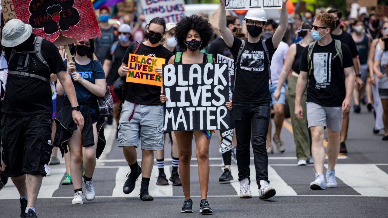 A woman marches to the White House at the head of a group of members and allies of the LGBTQ community as part of the Pride and Black Lives Matter movements on June 13, 2020, in Washington. Official Pride events were canceled due to the coronavirus pandemic but people showed up to lend support to the Black Lives Matter movement.