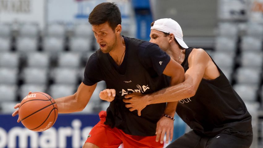 This photograph taken on June 18, 2020, shows Serbia's Novak Djokovic (L) and Bulgaria's Grigor Dimitrov, tennis players, as they take part in an exhibition basketball match in Zadar. - Croatia's Borna Coric announced on June 22, 2020, that he has become the second player to test positive for coronavirus after taking part in an exhibition tournament in Croatia featuring world number one Novak Djokovic. "Hi everyone, I wanted to inform you all that I tested positive for COVID-19," the Croatian, ranked 33rd in the world, posted on Twitter. It follows the June 21, announcement by Grigor Dimitrov that he had also tested positive after pulling out of the exhibition event, which is one of the biggest since the tennis season was halted because of the pandemic. (Photo by STRINGER / AFP) / Croatia OUT (Photo by STRINGER/AFP via Getty Images)