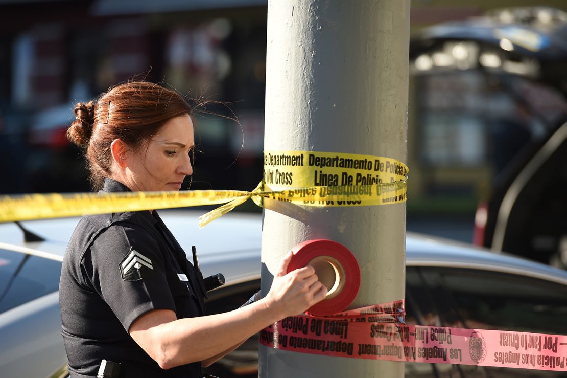 A female police officer uses police tape to cordon off an area outside a restaurant in Hollywood, California, in January 2017.