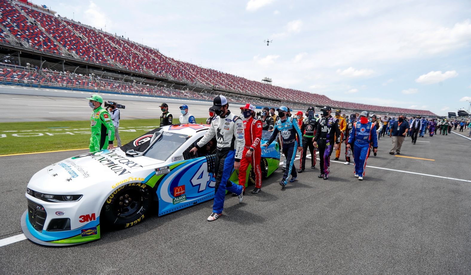 NASCAR drivers, pit crew members and others <a href="index.php?page=&url=https%3A%2F%2Fwww.cnn.com%2F2020%2F06%2F22%2Fus%2Fnascar-race-bubba-wallace-talladega%2Findex.html" target="_blank">show their support for Bubba Wallace</a> as they walk alongside his No. 43 car before a Cup Series race in Talladega, Alabama, on June 22. Wallace, the only Black driver in NASCAR's top circuit, has been an outspoken advocate of the Black Lives Matter movement and the corresponding protests against racism and police brutality. A noose was found in his garage stall on Sunday. The FBI investigated and concluded that the noose was a garage-door pull rope that had been in place as early as October 2019 -- well before it had been assigned to Wallace's team.