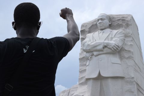 A man kneels and raises his fist in the air at the Martin Luther King Jr. Memorial in Washington, DC, on June 19.