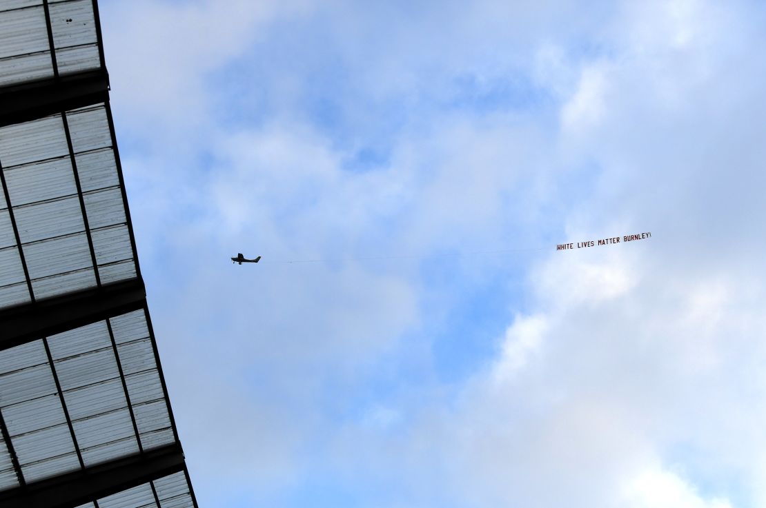 A plane flies over the Etihad Stadium with a banner reading "White Lives Matter Burnley."  