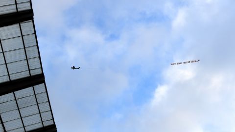 A plane flies over the Etihad Stadium with a banner reading "White Lives Matter Burnley."  