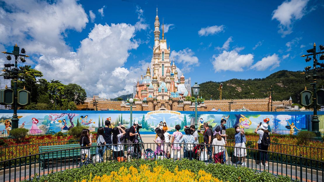 Visitors take photos in front of the Castle of Magical Dreams at Hong Kong's Disneyland on June 18. The California version hopes to reopen on July 17 but has delayed that plan for now.