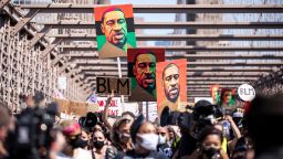 MANHATTAN, NY - JUNE 19:  Thousands of protesters walk in a peaceful protest across the Brooklyn Bridge holding signs that read, "BLM" and three painted portraits of George Floyd with the Brooklyn Bridge Arch in the background.  This was part of the Unite NY 2020, Bringing all of New York Together rally and march as protests that happened around the country to celebrate Juneteenth day which marks the end of slavery in the United States. Protesters continue taking to the streets across America and around the world after the killing of George Floyd at the hands of a white police officer Derek Chauvin that was kneeling on his neck during for eight minutes, was caught on video and went viral.  During his arrest as Floyd pleaded, "I Can't Breathe". The protest are attempting to give a voice to the need for human rights for African American's and to stop police brutality against people of color.  They are also protesting deep-seated racism in America.   Many people were wearing masks and observing social distancing due to the coronavirus pandemic.  Photographed in the Manhattan Borough of New York on June 19, 2020, USA.  (Photo by Ira L. Black/Corbis via Getty Images)