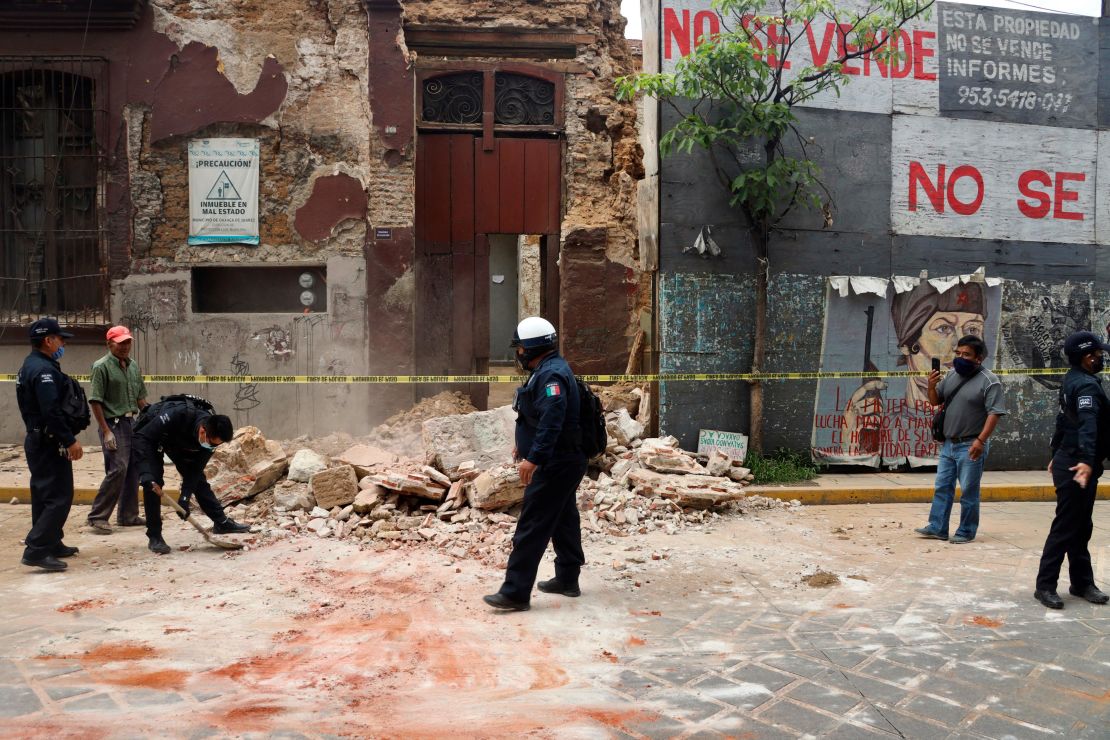 A policeman removes rubble from a building damaged by the earthquake in Oaxaca, Mexico.
