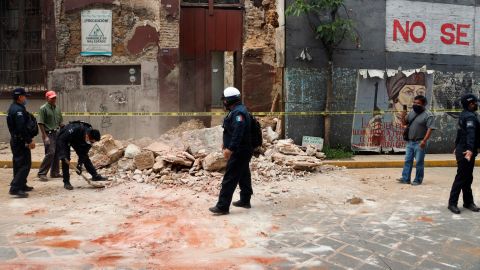 A policeman removes rubble from a building damaged by the earthquake in Oaxaca, Mexico.