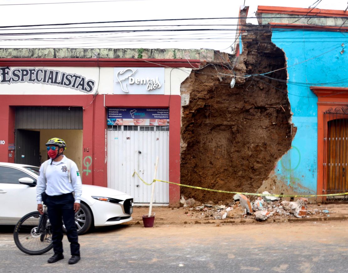 A policeman stands in front of a partially collapsed building after an earthquake in Oaxaca, Mexico.