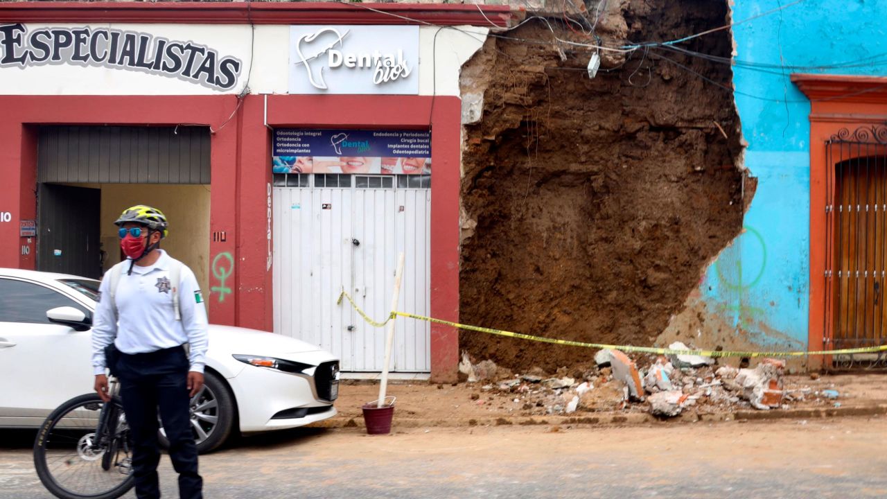 A policeman stands in front of a partially collapsed building after an earthquake in Oaxaca, Mexico.