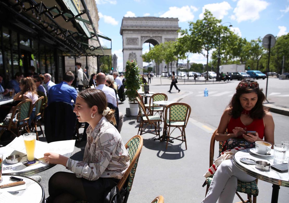 People have lunch at a restaurant near the Arc de Triomphe in Paris, France, on June 18.