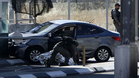 Israeli security forces cover the body of Palestinian Ahmad Erekat, who was shot dead at a checkpoint near Abu Dis in the West Bank.