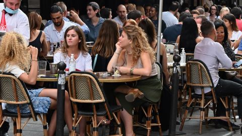 People eat and have drinks   at a cafe  terrace in the rue de Buci in Paris on June 2, 2020, as cafes and restaurants reopen in France with the easing of lockdown mesures taken to curb the spread of the COVID-19 pandemic, caused by the novel coronavirus. - French cafes and restaurants reopened their doors on June 2 as the country took its latest step out of coronavirus lockdown, with clients seizing the chance to bask on sunny terraces after 10 weeks of closures to fight the outbreak. (Photo by BERTRAND GUAY / AFP) (Photo by BERTRAND GUAY/AFP via Getty Images)