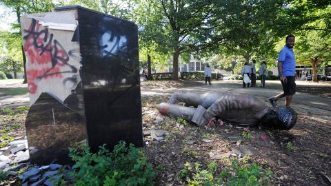 An unidentified man walks past a toppled statue of Charles Linn, a city founder who was in the Confederate Navy, in Birmingham, Ala., on June 1.
