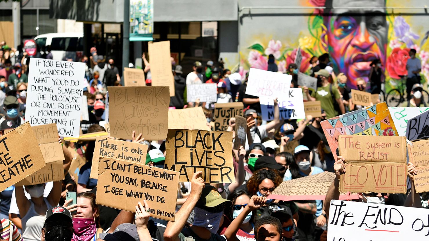 Marchers walk by a mural of George Floyd along Colfax Avenue on June 7, 2020, in Denver, Colorado.   (Photo by Helen H. Richardson/MediaNews Group/The Denver Post via Getty Images)