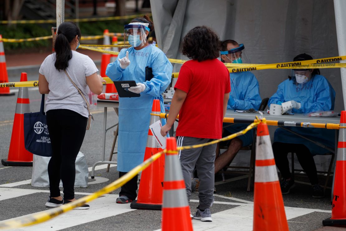 Medical personnel assist people in line for free Covid-19 testing in Washington, DC, on June 17.