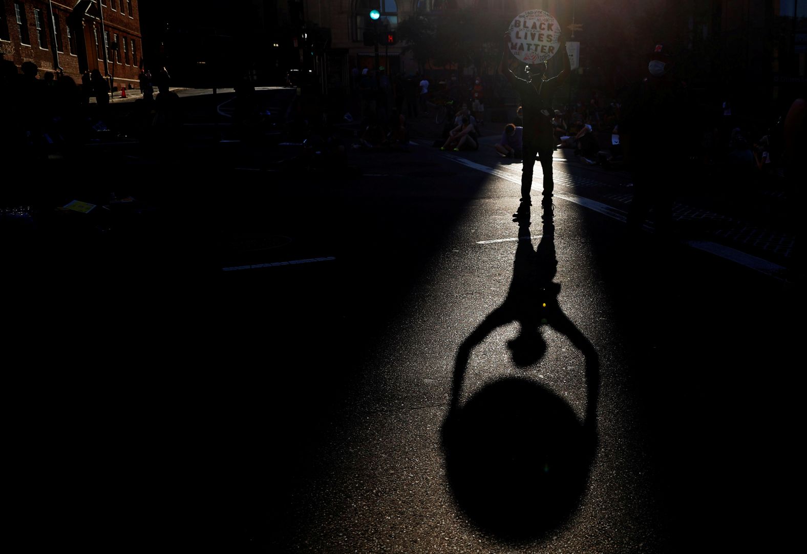 A man holds a Black Lives Matter sign as demonstrators block a Boston intersection on June 23. 