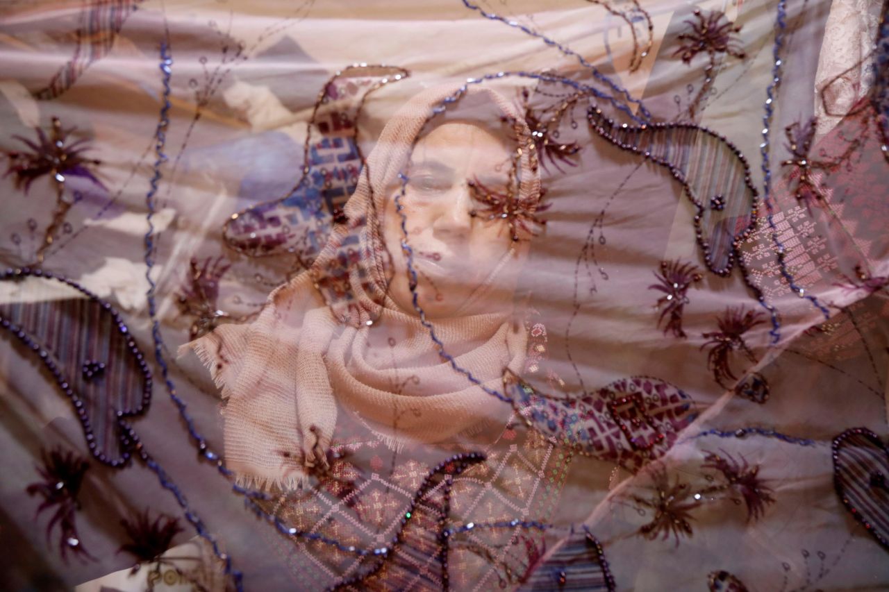 Manal Al-Essa can be seen through a dress in Tubas, West Bank, on Tuesday, June 23. Al-Essa, whose husband died of cancer, sewed the dress herself and was selling it on International Widows Day.