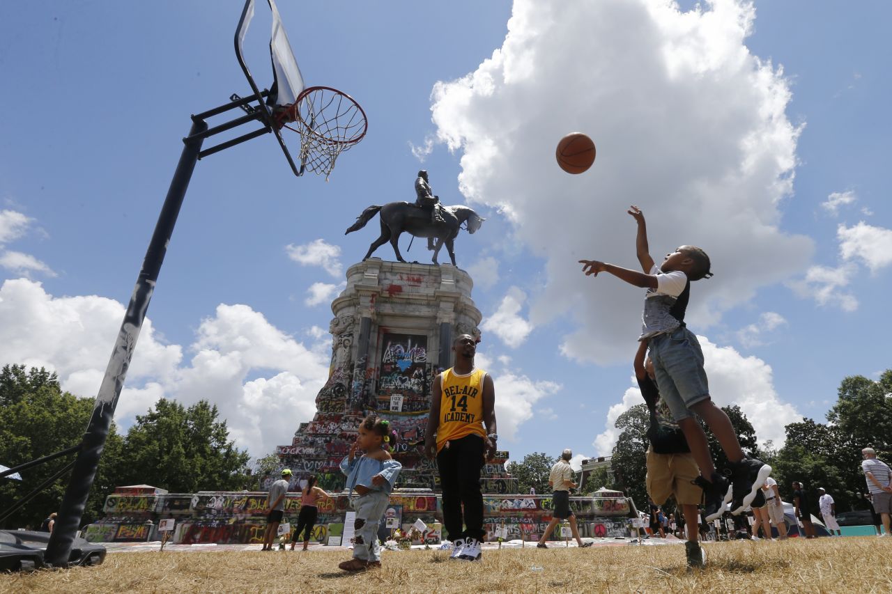 Isaiah Bowen plays basketball Sunday, June 21, near a statue of Confederate Gen. Robert E. Lee in Richmond, Virginia. A judge <a href="https://www.cnn.com/2020/06/09/politics/judge-blocks-removal-robert-e-lee-statue-richmond/index.html" target="_blank">temporarily blocked the removal of the statue</a> after Virginia Gov. Ralph Northam announced plans to take it down. 