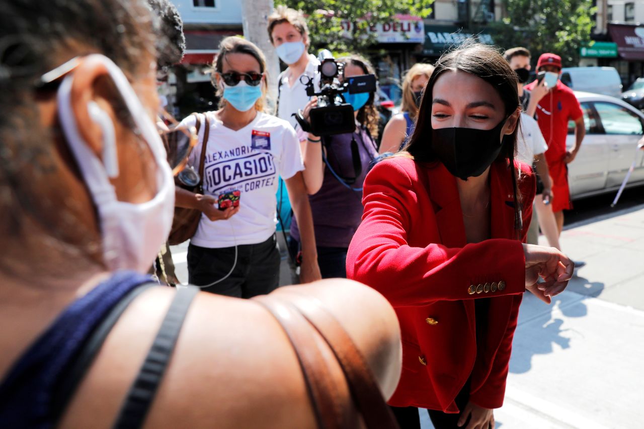 US Rep. Alexandria Ocasio-Cortez bumps elbows with local resident Upkar Chana while greeting voters in New York on Tuesday, June 23. <a href="https://www.cnn.com/2020/06/23/politics/aoc-ny-primary-14th-district/index.html" target="_blank">Ocasio-Cortez won her Democratic primary that day,</a> defeating former CNBC correspondent Michelle Caruso-Cabrera.