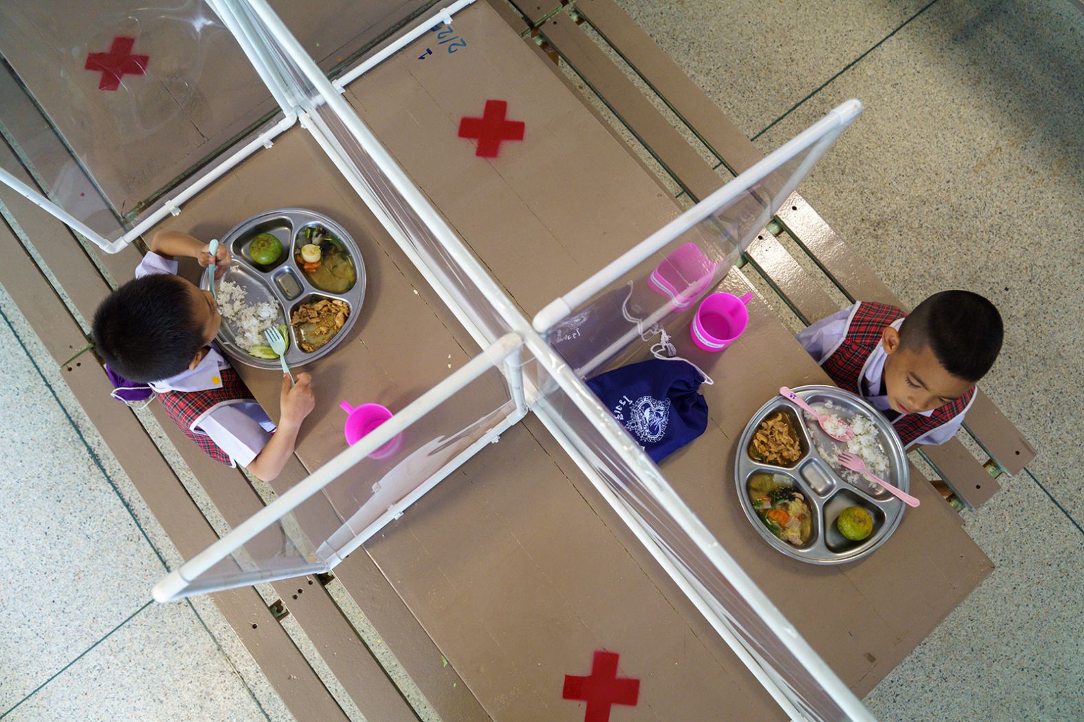 Kindergarten students from the Wichuthit school eat lunch behind screens in Bangkok, Thailand, on June 23.