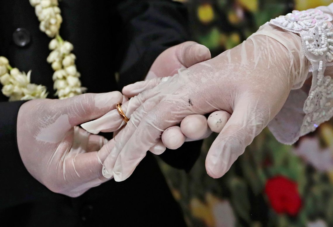 Octavianus Kristianto puts a ring on his new bride, Elma Divani, during their wedding ceremony in Pamulang, Indonesia, on Friday, June 19. They were wearing latex gloves to prevent the spread of the coronavirus.