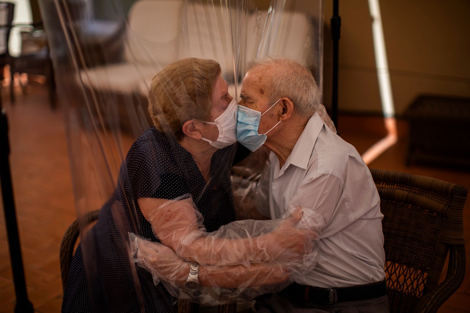 Agustina Cañamero and Pascual Pérez kiss each other through a plastic screen at a nursing home in Barcelona, Spain, on June 22. They've been married for 59 years.