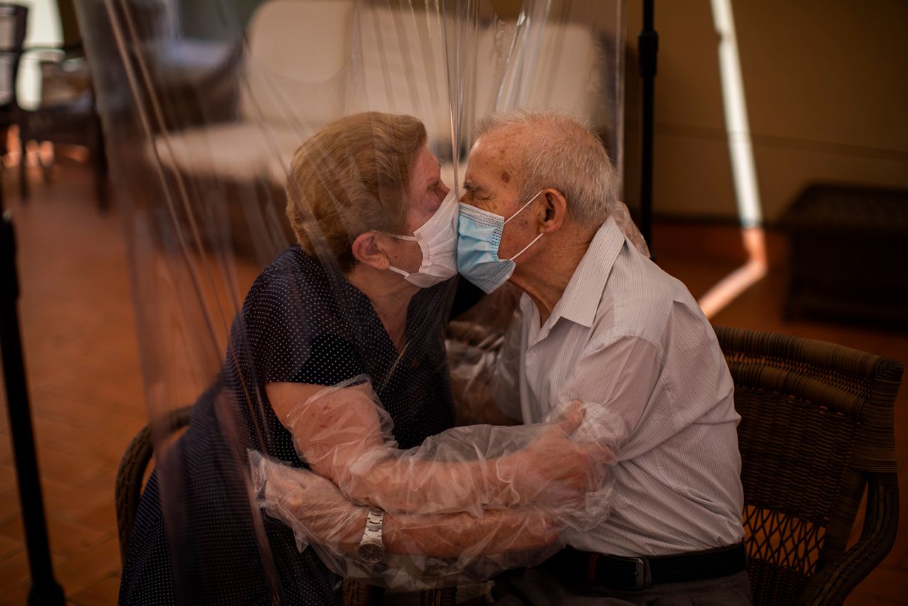 Agustina Cañamero and Pascual Pérez kiss each other through a plastic screen at a nursing home in Barcelona, Spain, on Monday, June 22. They've been married for 59 years.