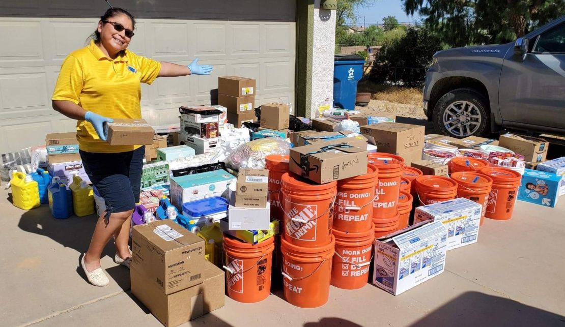 Theresa Hatathlie smiles next to sewing and hygiene supplies donated by the Auntie Sewing Squad.