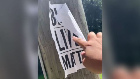 A screengrab from a video in which a far-right group member rips a Black Lives Matter poster from a tree.