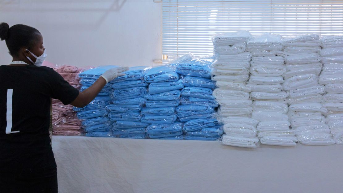 A Tiffany Amber employee sorts ready-to-ship gowns for healthcare workers.