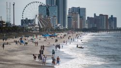 MYRTLE BEACH, SC - MAY 23: People walk and gather  along the beach on the morning of May 23, 2020 in Myrtle Beach, South Carolina. Businesses, including amusements, have reopened for the Memorial Day holiday weekend after forced pandemic closures. (Photo by Sean Rayford/Getty Images)