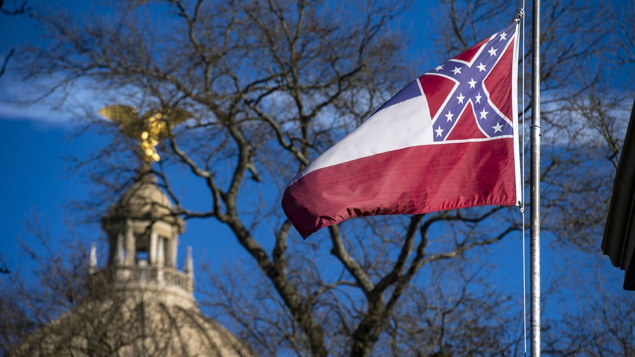 The Mississippi State Capitol dome is visible in the distance as the state flag flies in 2019 in Jackson. 