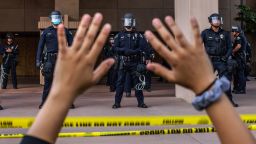 A demonstrator holds her hands up while she kneels in front of the Police at the Anaheim City Hall on June 1, 2020 in Anaheim, California, during a peaceful protest over the death of George Floyd. - Major US cities -- convulsed by protests, clashes with police and looting since the death in Minneapolis police custody of George Floyd a week ago -- braced Monday for another night of unrest. More than 40 cities have imposed curfews after consecutive nights of tension that included looting and the trashing of parked cars. (Photo by Apu GOMES / AFP) (Photo by APU GOMES/AFP via Getty Images)