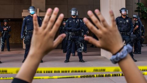 A demonstrator holds her hands up while she kneels in front of the Police at the Anaheim City Hall on June 1, 2020 in Anaheim, California, during a peaceful protest over the death of George Floyd. 